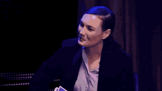a woman is sitting at a table with the word what written in pink .
