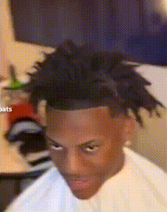 a man with dreadlocks is sitting in a chair and looking at the camera