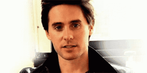 a close up of a man 's face wearing a black jacket .