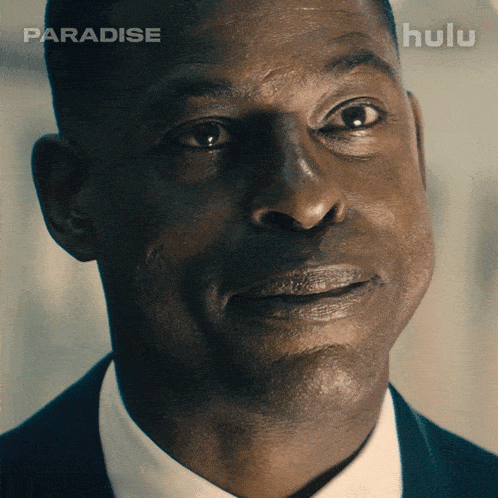 a close up of a man 's face with a hulu logo in the background