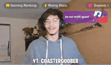 a man wearing headphones and glasses is standing in front of a screen that says vt : coastergoober