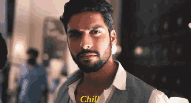 a man with a beard is looking at the camera and says chill