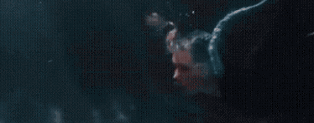 a woman with blue hair has a tattoo on her face that says ' a ' on it