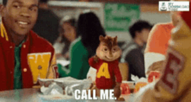 alvin the chipmunk says call me while sitting at a table with a group of people
