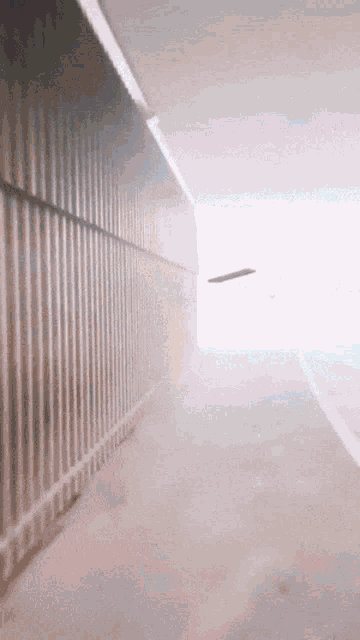 a skateboard is flying through a tunnel with a white wall