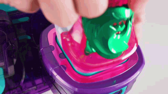 a person is playing with a toy that has a frog on it