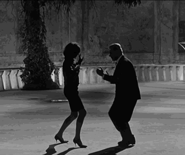a man and a woman are dancing together in a black and white photo