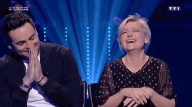 a man and a woman are laughing together on a tv show called tfi