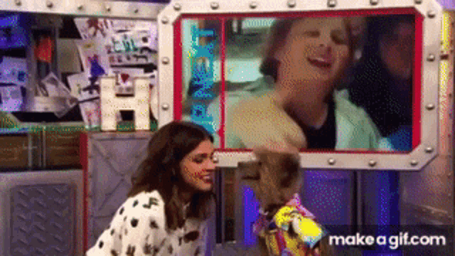 a woman is petting a stuffed animal in front of a picture of a man and woman .