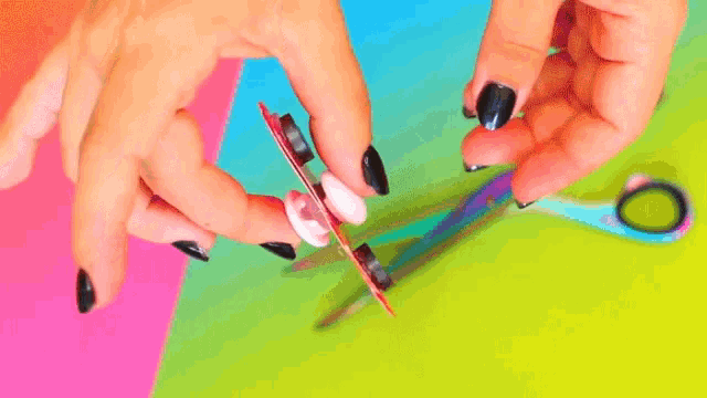 a person is holding a fidget spinner and scissors .