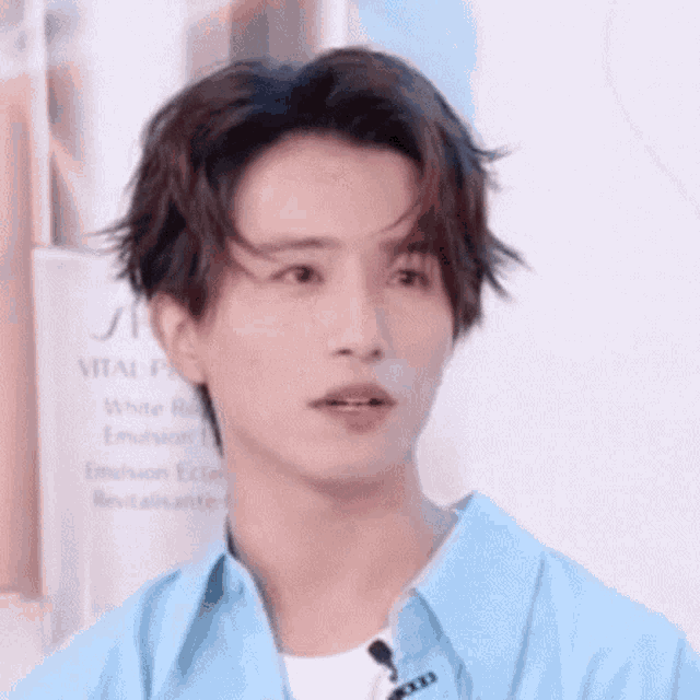 a close up of a young man wearing a blue shirt and a white t-shirt .
