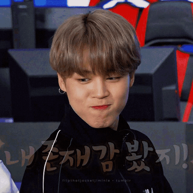 a close up of a person making a funny face with korean writing behind them