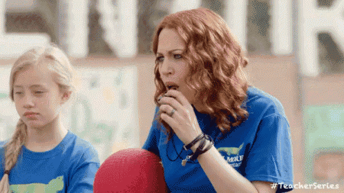 a woman is blowing a whistle while sitting next to a girl .