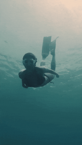 a person is swimming in the ocean with a mask on