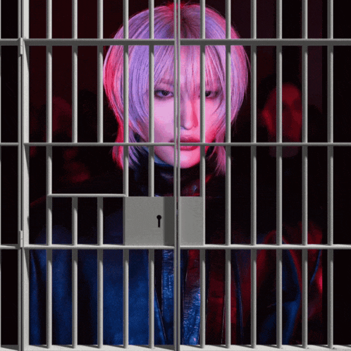 a woman with purple hair is behind bars