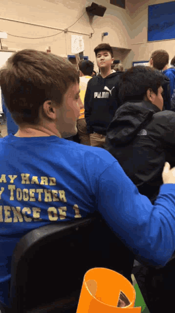 a boy wearing a blue shirt that says stay hard together science of 1