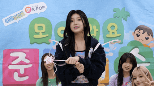 a girl is holding a wand in front of a banner that says all the k-pop