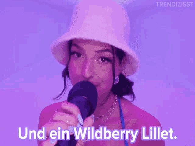 a woman singing into a microphone with the words und ein wildberry lillet on the bottom