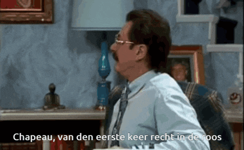 a man with glasses and a mustache says " chapeau van den eerste keer recht in de roops "