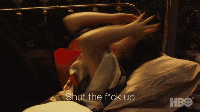 a woman is laying in bed with the words shut the f * ck up written above her