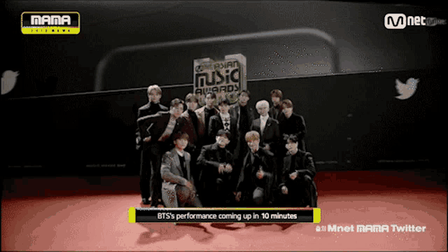 a group of young men are posing for a photo in front of a sign that says mama