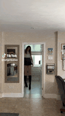 a woman is standing in a doorway with a tiktok sticker