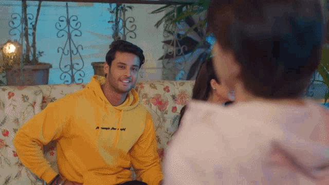 a man wearing a yellow hoodie that says ' i 'm always free and wild ' on it