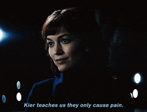 a woman in a dark room with the words " kier teaches us they only cause pain "