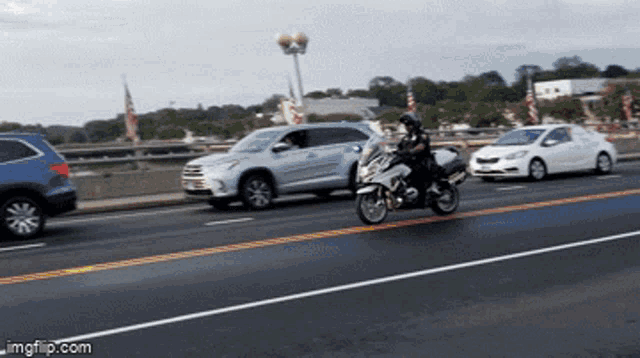 a person riding a motorcycle on a highway with a watermark of imgflip.com