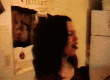 a woman is standing in front of a juliet poster