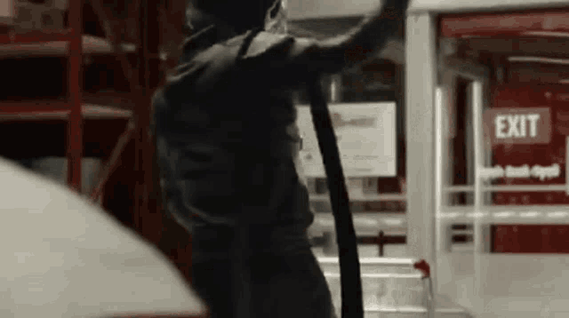a person is standing in front of an exit sign .