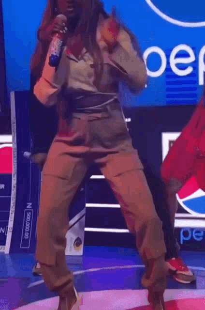 a woman is dancing in front of a pepsi ad