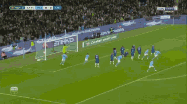 a soccer game is being played in front of a banner that says etihad on it