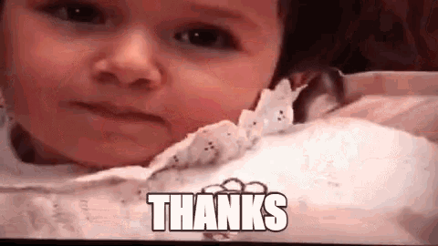 a close up of a baby 's face with the words thanks written on it