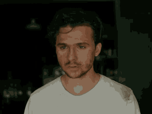 a man with a beard wearing a white t-shirt