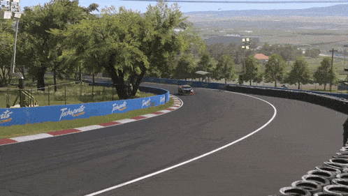 a race car is going down a track with a blue fence that says torrents
