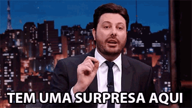 a man in a suit and tie says tem uma surpresa aqui in a foreign language