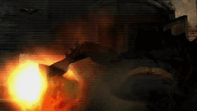 a person is holding a gun in front of a fire and smoke