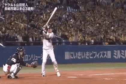 a baseball player is swinging a bat at a pitch while a catcher looks on .