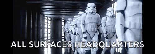a row of stormtroopers walking down a hallway with the words `` all surfaces headquarters ''