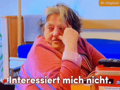 an elderly woman sitting in a bed with interestiert mich nicht written on her face