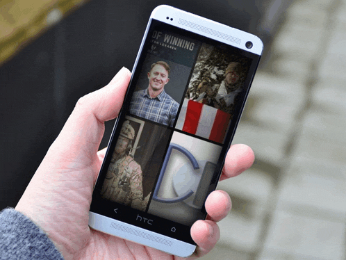 a person is holding an htc phone with a collage of photos on the screen