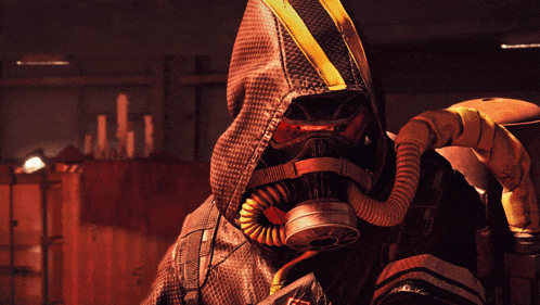 a person wearing a gas mask and a hooded jacket with a red light behind them