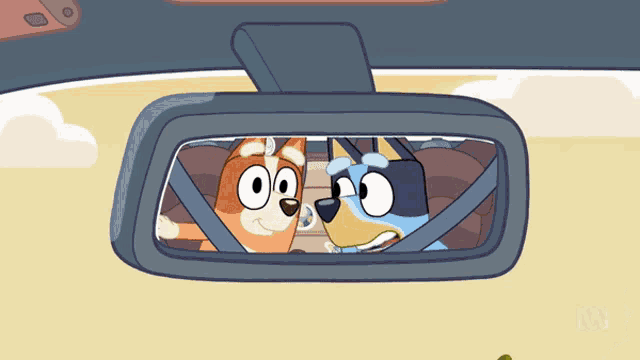 two cartoon dogs are looking at each other in the rear view mirror