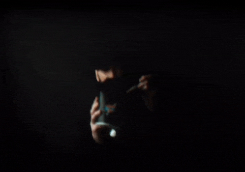 a man with a beard is holding a plate of food in a dark room