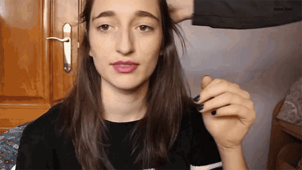 a woman 's face is being touched by a person 's hand