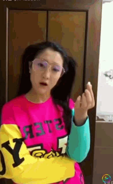 a woman wearing glasses and a pink shirt that says " y " on it