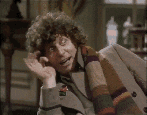 a man with curly hair is wearing a scarf around his neck and making a funny face .