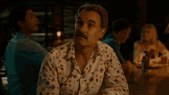 a man sitting at a table with a glass of whiskey and the words that 's a telltale sign below him