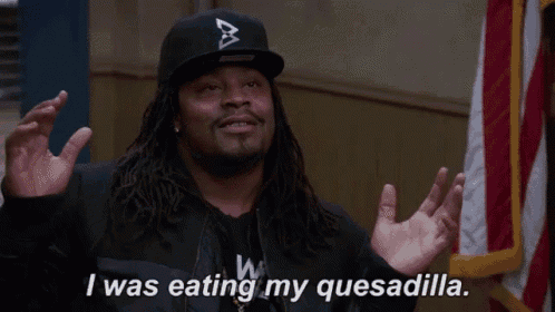 a man wearing a black hat and a black jacket says i was eating my quesadilla